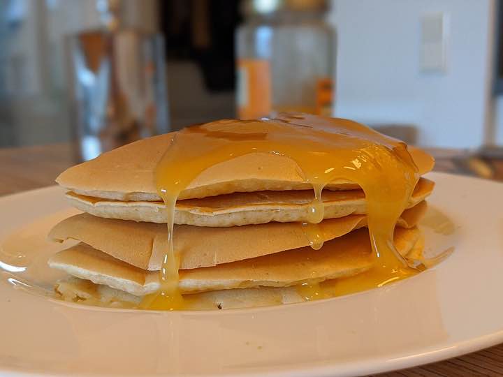 A stack of pancakes with honey