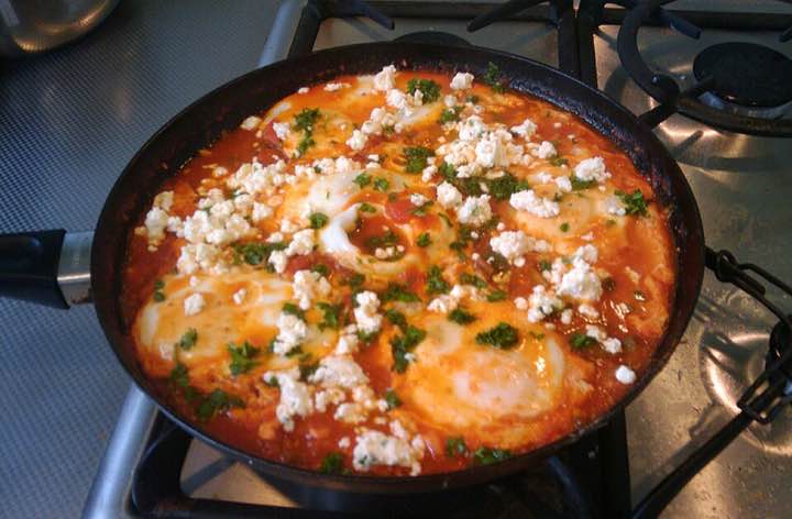 Shakshuka: eggs poached in a pan of tomato and pepper sauce